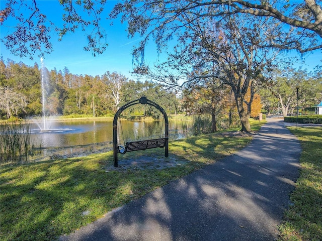 surrounding community featuring a lawn and a water view