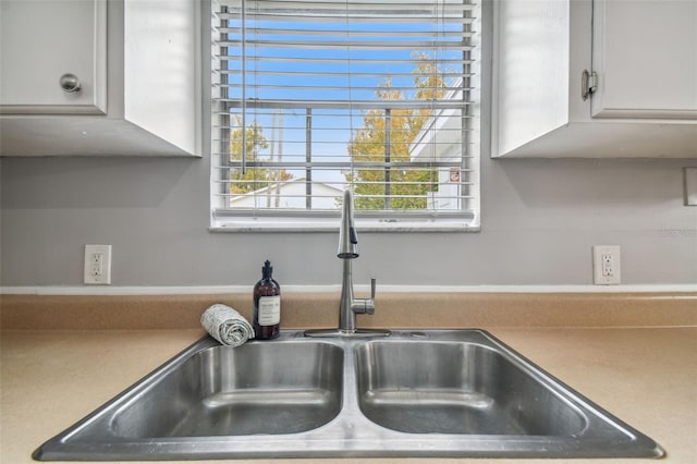 interior details featuring white cabinetry and sink