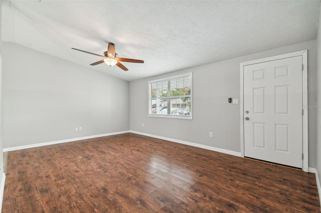 spare room featuring a textured ceiling, ceiling fan, dark wood-type flooring, and vaulted ceiling