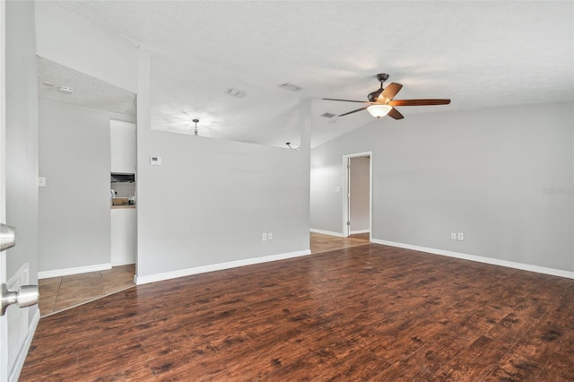 empty room featuring vaulted ceiling, ceiling fan, dark wood-type flooring, and a textured ceiling