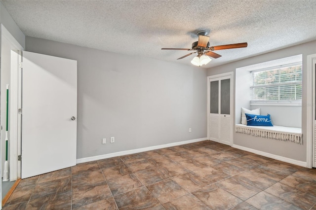 unfurnished room featuring ceiling fan and a textured ceiling