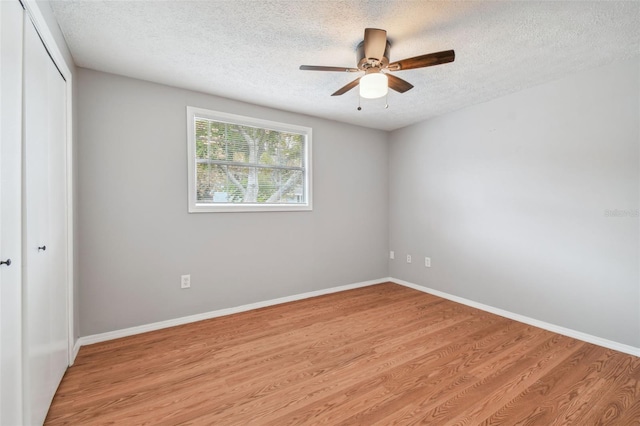 unfurnished bedroom with a closet, ceiling fan, light hardwood / wood-style flooring, and a textured ceiling