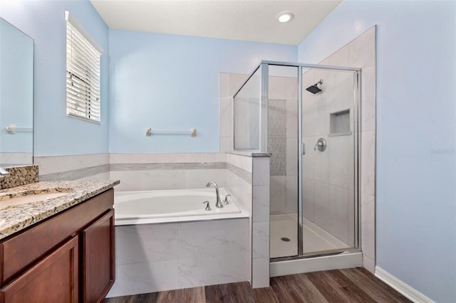 bathroom with vanity, hardwood / wood-style floors, and plus walk in shower