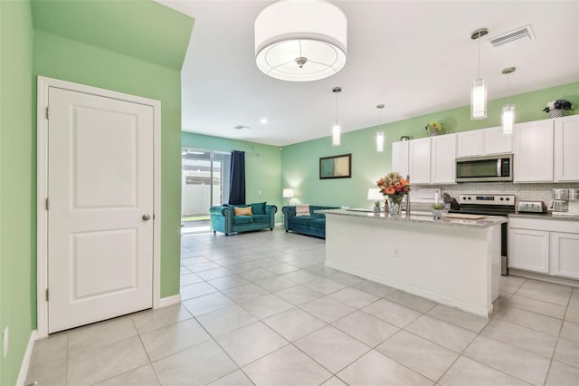 kitchen featuring an island with sink, decorative light fixtures, decorative backsplash, white cabinets, and appliances with stainless steel finishes