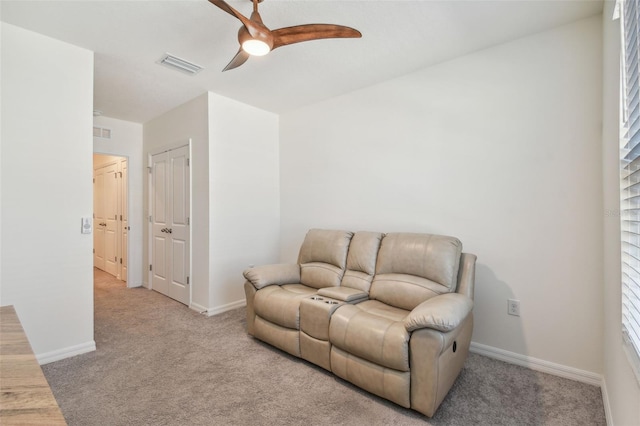 living area with ceiling fan and light carpet