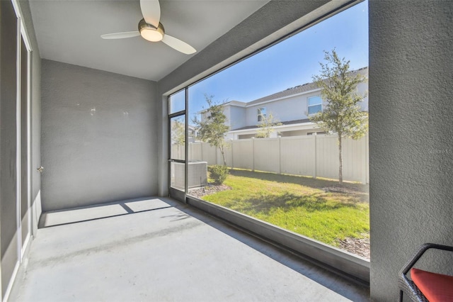 unfurnished sunroom with ceiling fan