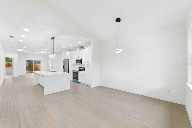 kitchen with sink, decorative light fixtures, a center island with sink, white cabinets, and appliances with stainless steel finishes