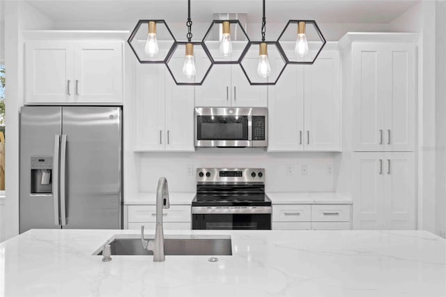 kitchen featuring decorative light fixtures, white cabinetry, and appliances with stainless steel finishes