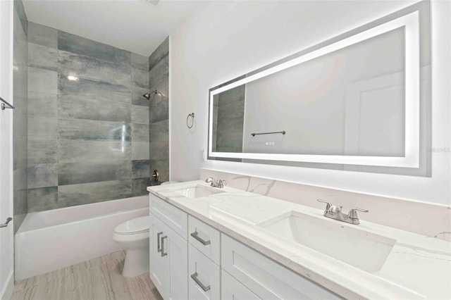 full bathroom with wood-type flooring, vanity, toilet, and tiled shower / bath