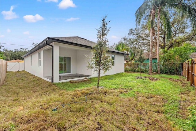 back of property featuring a yard and a patio