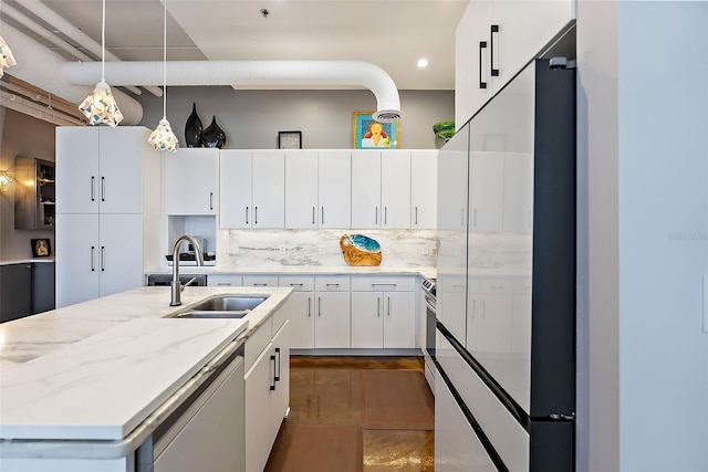 kitchen featuring backsplash, stainless steel appliances, sink, white cabinetry, and an island with sink