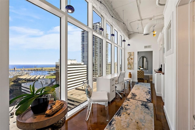 corridor featuring a water view and a high ceiling