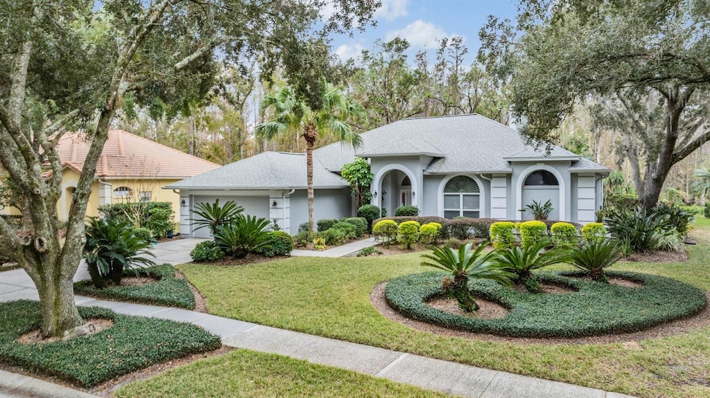 view of front of house with a garage and a front lawn