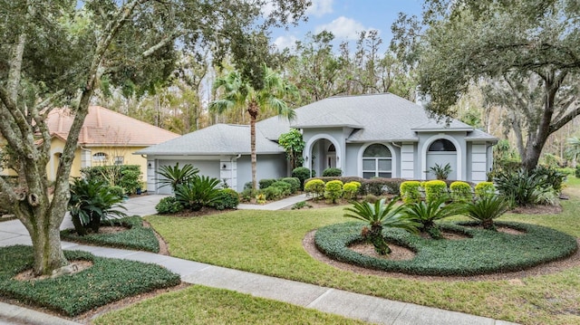 view of front of house with a garage and a front lawn