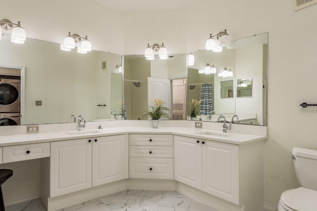 bathroom with vanity, toilet, walk in shower, and stacked washer and clothes dryer