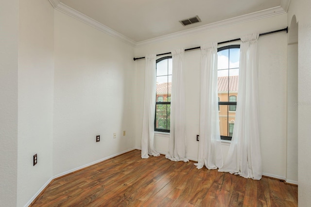 empty room with dark hardwood / wood-style floors and crown molding