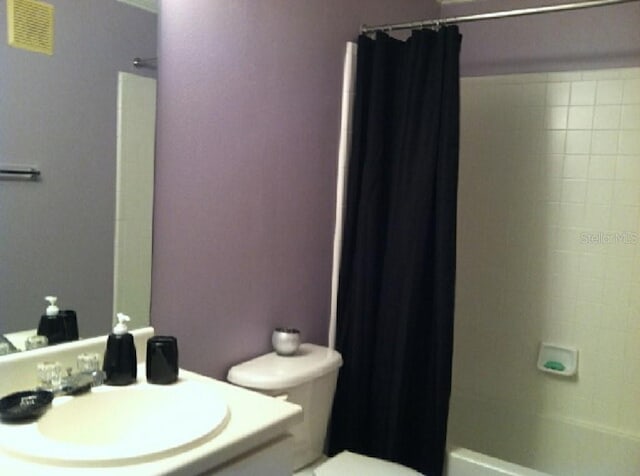 full bathroom featuring shower / bath combo, vanity, and toilet