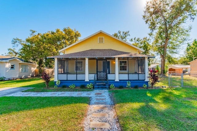 bungalow with a sunroom and a front yard