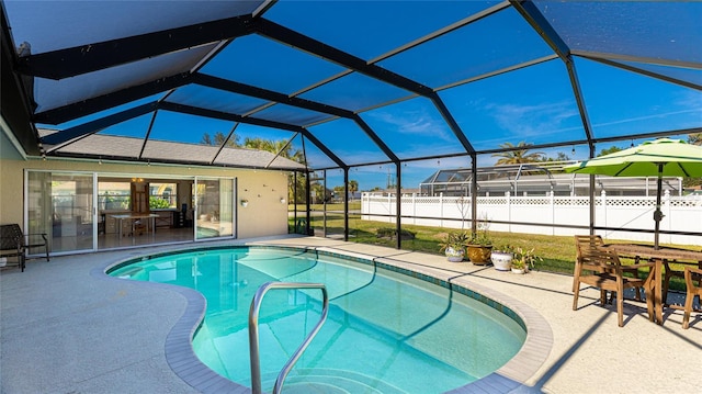 view of pool featuring glass enclosure and a patio