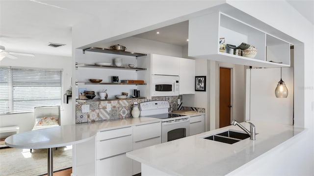 kitchen with sink, white appliances, white cabinets, and ceiling fan