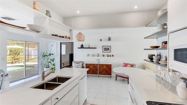 kitchen featuring white cabinetry and sink