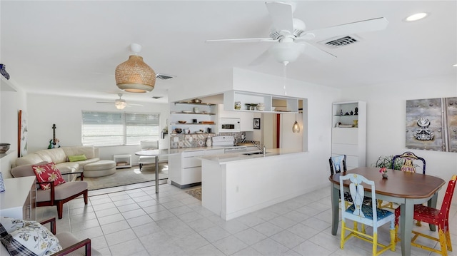 living room featuring sink, light tile patterned floors, and ceiling fan