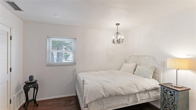 bedroom with an inviting chandelier and dark hardwood / wood-style flooring