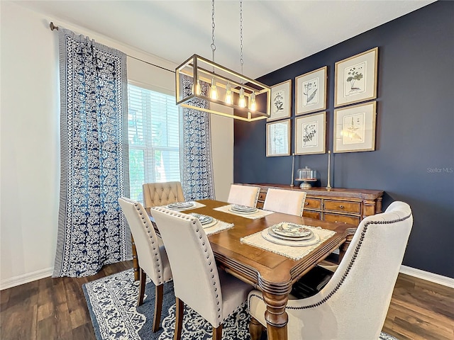 dining area with dark wood-type flooring and a chandelier