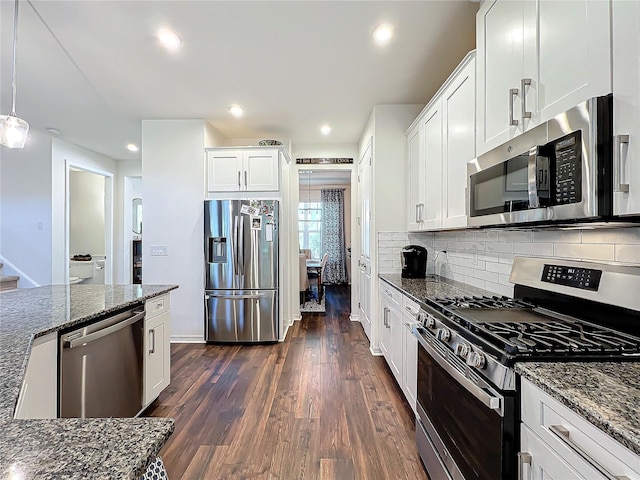 kitchen with white cabinetry, dark hardwood / wood-style flooring, dark stone countertops, and appliances with stainless steel finishes