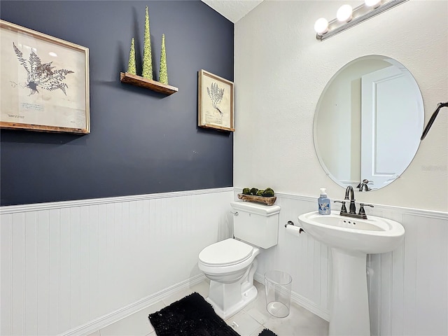 bathroom with tile patterned flooring, sink, and toilet