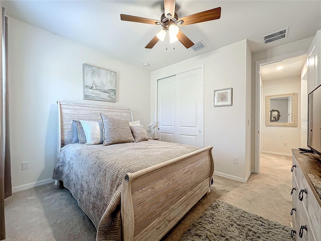 carpeted bedroom with ceiling fan and a closet