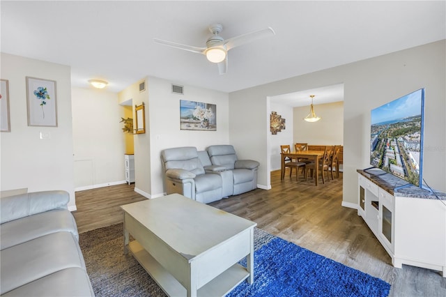 living room featuring dark hardwood / wood-style floors and ceiling fan