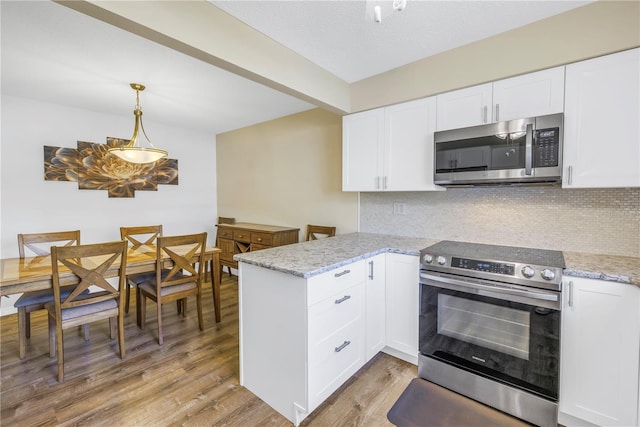 kitchen featuring white cabinetry, light stone counters, pendant lighting, light hardwood / wood-style floors, and appliances with stainless steel finishes