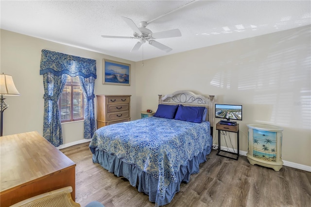 bedroom featuring hardwood / wood-style floors, ceiling fan, and a textured ceiling