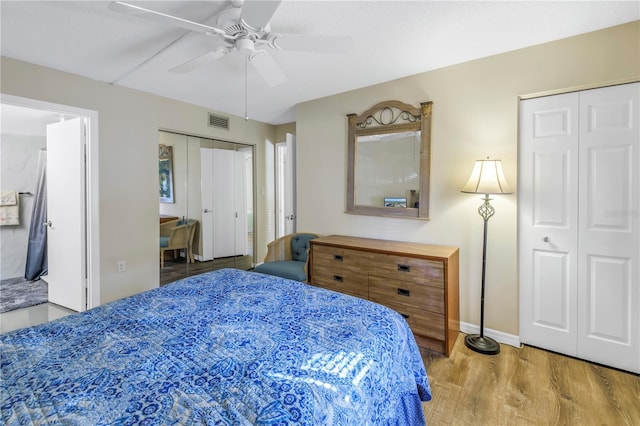 bedroom with ceiling fan, hardwood / wood-style floors, and two closets