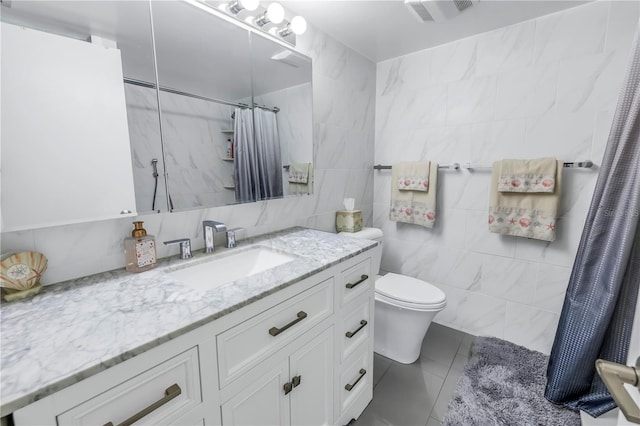 bathroom with vanity, tile patterned floors, toilet, tile walls, and curtained shower