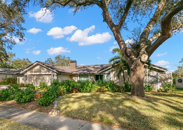 view of front of home with a garage and a front lawn