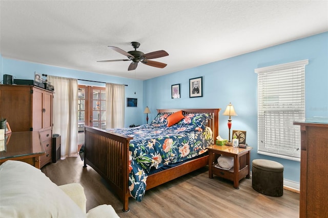 bedroom featuring ceiling fan, wood-type flooring, and a textured ceiling