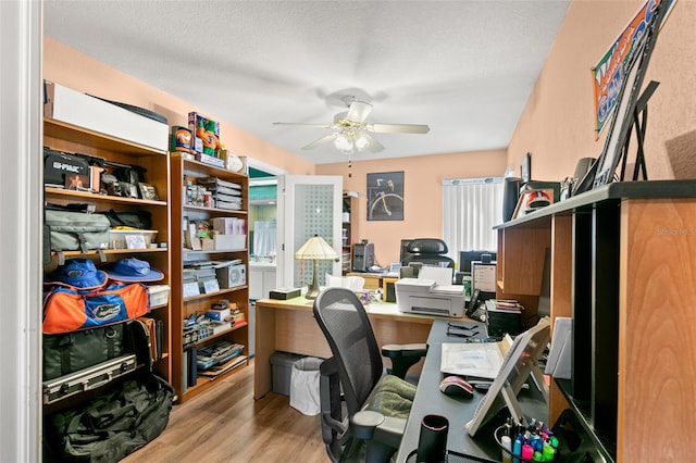 office area featuring ceiling fan, light hardwood / wood-style floors, and a textured ceiling