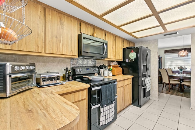 kitchen with tasteful backsplash, stainless steel appliances, light tile patterned floors, an inviting chandelier, and hanging light fixtures