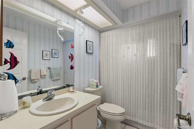 bathroom with tile patterned flooring, vanity, and toilet