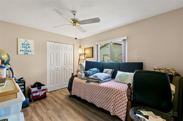 bedroom with hardwood / wood-style floors, ceiling fan, and a closet