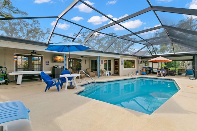 view of swimming pool featuring ceiling fan, a lanai, and a patio