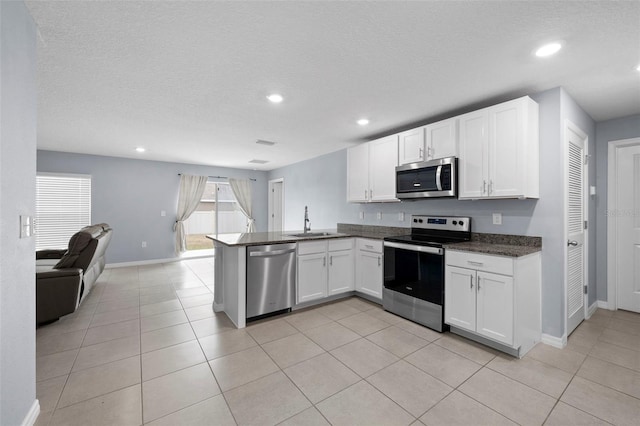 kitchen featuring white cabinets, sink, kitchen peninsula, and stainless steel appliances