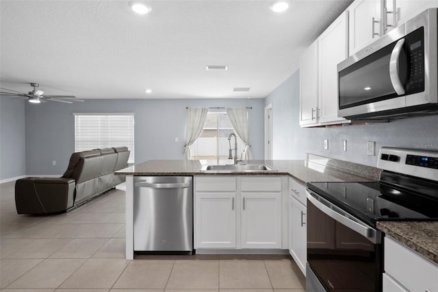 kitchen featuring kitchen peninsula, stainless steel appliances, white cabinetry, and sink