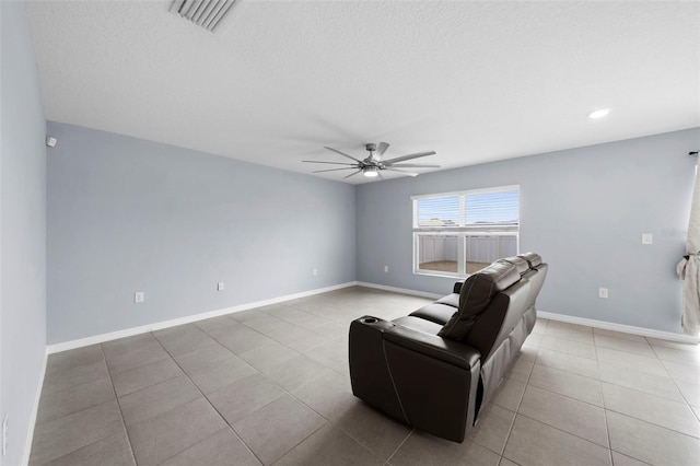 tiled living room featuring ceiling fan and a textured ceiling