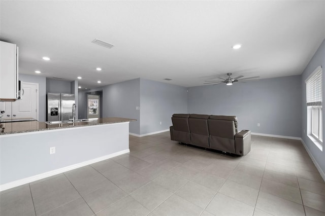 unfurnished living room featuring ceiling fan and light tile patterned flooring