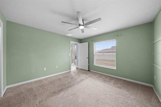 carpeted empty room with ceiling fan and a textured ceiling