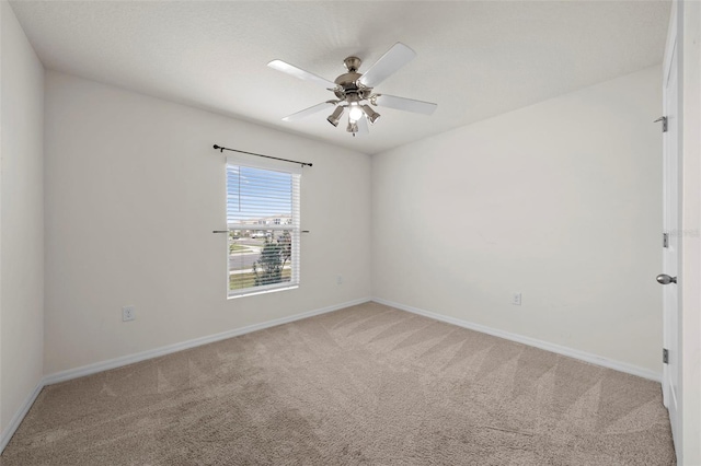 spare room with ceiling fan and light carpet