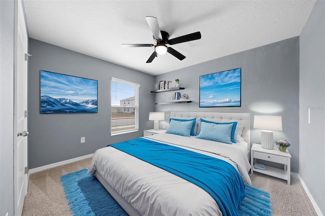 bedroom with ceiling fan, light carpet, and a textured ceiling